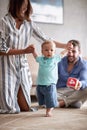Happy young family playing and baby learning to walk at home Royalty Free Stock Photo