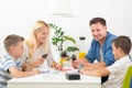 Happy young family playing card game at dining table at bright modern home. Royalty Free Stock Photo