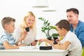 Happy young family playing card game at dining table at bright modern home. Royalty Free Stock Photo