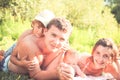 Happy young family portrait with two children on grass during summer holidays