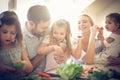 Happy young family preparing salad together.