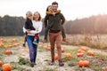 Happy young family in pumpkin patch field Royalty Free Stock Photo