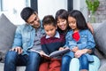 Happy young family reading a book together