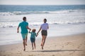 Happy young family run and jump on summer beach. Family leisure activities concept. Child with parents running and