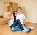 Happy young family showing thumbs up on a background of cardboard Royalty Free Stock Photo