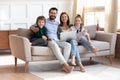 Happy young family sit on couch using modern laptop