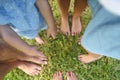 Happy young family spending time outdoor on a summer day. Feet on the grass Royalty Free Stock Photo