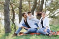 Happy young family spending time outdoor on a summer day have fun at beautiful park in nature while sitting on the green grass. Royalty Free Stock Photo