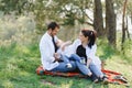 Happy young family spending time outdoor on a summer day have fun at beautiful park in nature while sitting on the green grass. Royalty Free Stock Photo