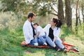 Happy young family spending time outdoor on a summer day have fun at beautiful park in nature while sitting on the green grass. Royalty Free Stock Photo