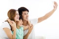 Happy young family taking selfies on sofa Royalty Free Stock Photo