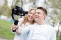 Happy young family taking video selfies with her camera on the gimbal steadycam