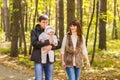 Happy young family with their daughter spending time outdoor in the autumn park Royalty Free Stock Photo