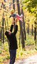 Happy young family with their daughter spending time outdoor in the autumn park. Royalty Free Stock Photo