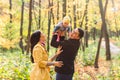 Happy young family with their daughter spending time outdoor in the autumn park Royalty Free Stock Photo