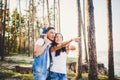 Happy young family of three people resting in a park outside the city. daughter sits at daddy on shoulders, and parents show direc Royalty Free Stock Photo