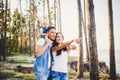 Happy young family of three people resting in a park outside the city. daughter sits at daddy on shoulders, and parents show direc Royalty Free Stock Photo