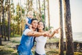 Happy young family of three people resting in a park outside the city. daughter sits at daddy on shoulders, and parents show Royalty Free Stock Photo