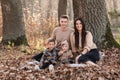 Happy young family with two little children relaxing and having fun in autumn park on sunny day. Royalty Free Stock Photo