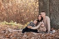 Happy young family with two little children relaxing and having fun in autumn park on sunny day Royalty Free Stock Photo