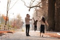 Happy young family with two little children walking and having fun in autumn park on sunny day Royalty Free Stock Photo