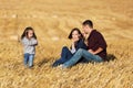 Happy young family with two year girl in harvested field Royalty Free Stock Photo