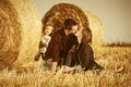 Happy young family with two year old baby girl next to hay bales in harvested field Royalty Free Stock Photo