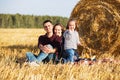 Happy young family with two year old girl next to hay bales Royalty Free Stock Photo