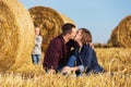 Happy young family with two year girl next to hay bales in field Royalty Free Stock Photo