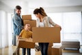 Happy young family unpacking cardboard boxes at new home Royalty Free Stock Photo