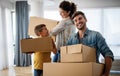 Happy young family unpacking cardboard boxes at new home Royalty Free Stock Photo