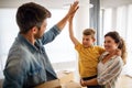 Happy young family unpacking cardboard boxes at new home Royalty Free Stock Photo