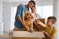 Happy young family unpacking cardboard boxes at new home Royalty Free Stock Photo