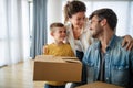 Happy young family unpacking cardboard boxes at new home Royalty Free Stock Photo