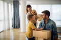 Happy young family unpacking cardboard boxes at new home Royalty Free Stock Photo