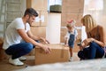 Young Family unpacking cardboard boxes in their new home Royalty Free Stock Photo