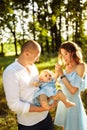 Happy young family walking at the park, caring parents play with little daughter, smiling, loving dad hold adorable baby Royalty Free Stock Photo