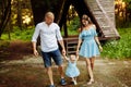 Happy young family walking at the park , little baby girl hold mother and father hands, mom and dad looking at beautiful Royalty Free Stock Photo