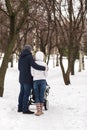 Happy young family walking in the park in winter Royalty Free Stock Photo