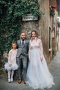 A happy young family walks through the old town of Sirmione in Italy.Stylish family in Italy on a walk Royalty Free Stock Photo