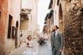 A happy young family walks through the old town of Sirmione in Italy.Stylish family in Italy on a walk Royalty Free Stock Photo