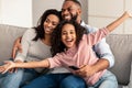 Happy young family watching television sitting on sofa Royalty Free Stock Photo