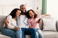 Happy young family watching television sitting on sofa Royalty Free Stock Photo