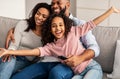 Happy young family watching television sitting on sofa Royalty Free Stock Photo