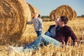 Happy young family with two year old girl next to hay bales in har Royalty Free Stock Photo