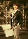 Young fashion business woman in leather jacket with file folder