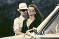 Happy young fashion couple next to vintage car