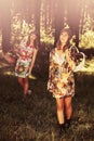 Happy young fashion girls with a fruit basket walking in summer forest Royalty Free Stock Photo