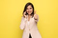 Happy young fashion model in pink suit making thumbs up sign Royalty Free Stock Photo