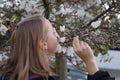 Woman smelling flower blossom white rhododendron bush